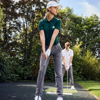 Bild vergr&ouml;&szlig;ern: Zwei Golfspieler, Mann und Frau, am Golfabschlag.